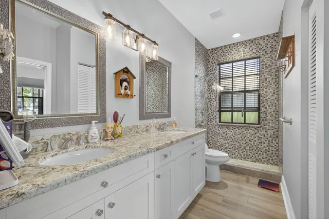 a bathroom with a granite countertop sink mirror and a toilet