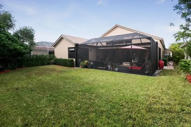 a view of a house next to a big yard and large trees
