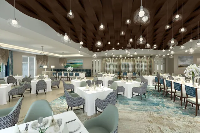 a room with lots of tables a large window and chairs