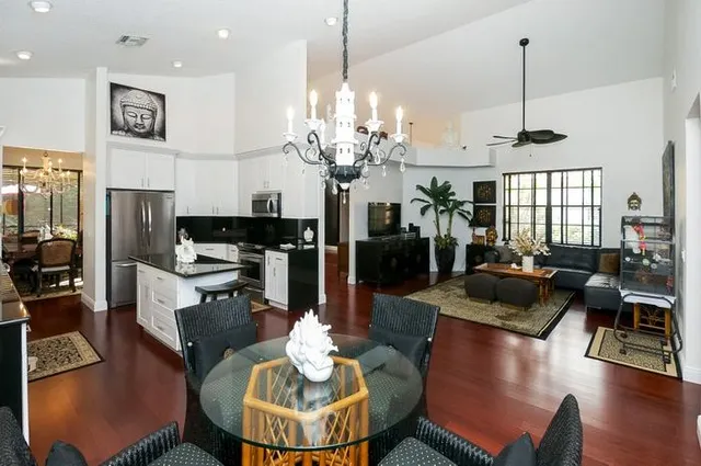 a kitchen with stainless steel appliances granite countertop a stove a kitchen island a dining table and chairs