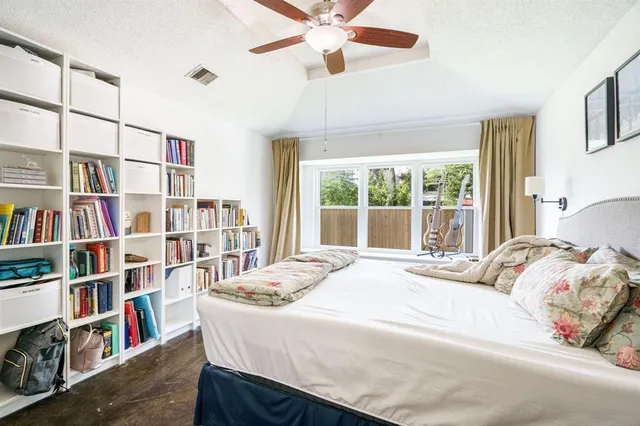 a bedroom with a bed book shelf and a window