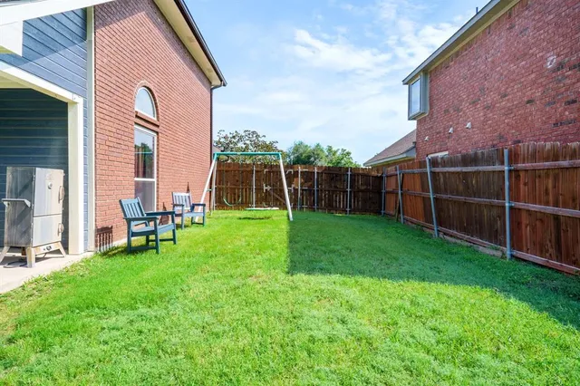 a view of a chair and table in backyard of the house