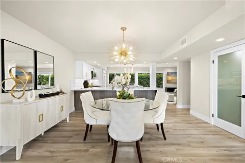 a dining room with furniture a chandelier and wooden floor