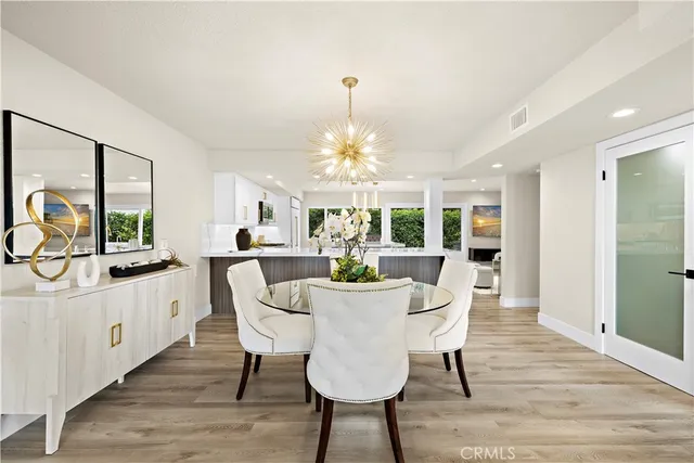 a dining room with furniture a chandelier and wooden floor