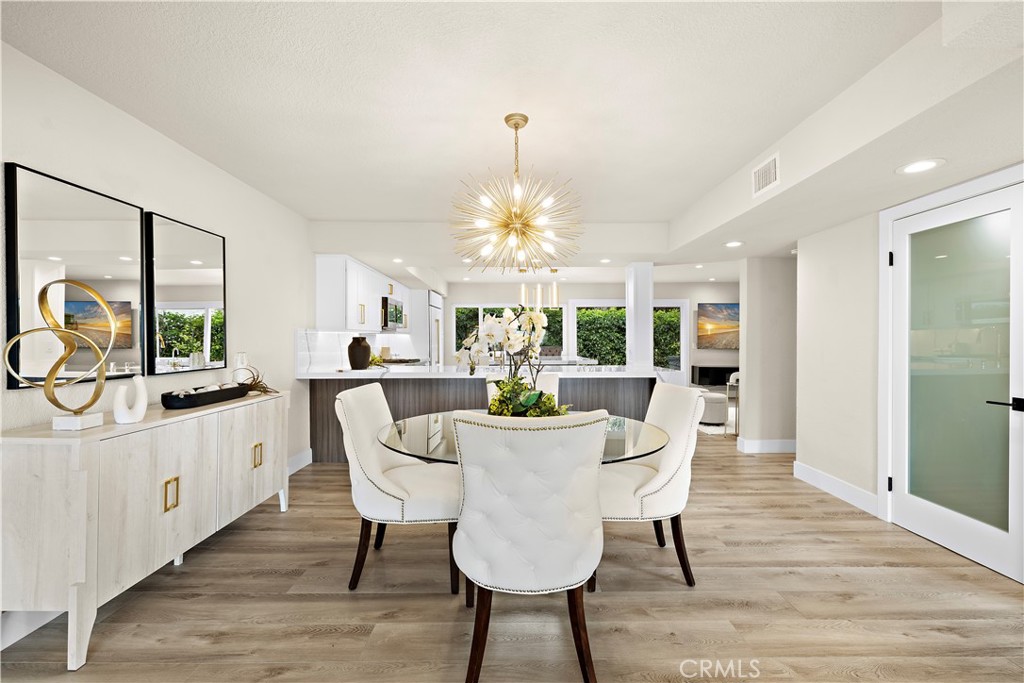 23277 Atlantis Way Dana Point, CA 92629 - Photo 11 of 48 a dining room with furniture a chandelier and wooden floor
