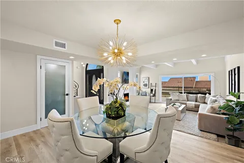 a dining room with furniture a chandelier and wooden floor