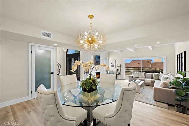 a dining room with furniture a chandelier and wooden floor
