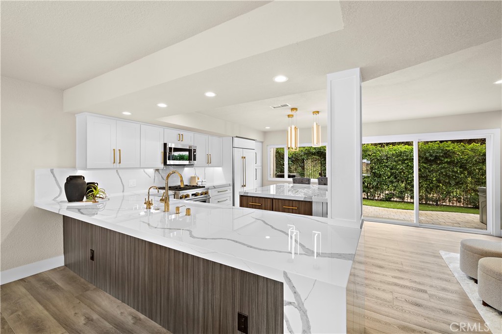 23277 Atlantis Way Dana Point, CA 92629 - Photo 15 of 48 a room with stainless steel appliances kitchen island granite countertop a refrigerator a sink a stove and a wooden floors