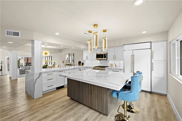 a large kitchen with a table chairs refrigerator and a sink