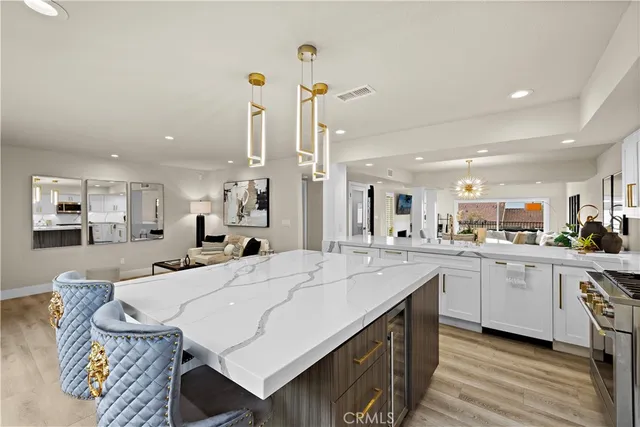 a large kitchen with kitchen island a sink table and chairs