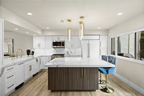 a large kitchen with kitchen island a counter space a sink appliances and cabinets