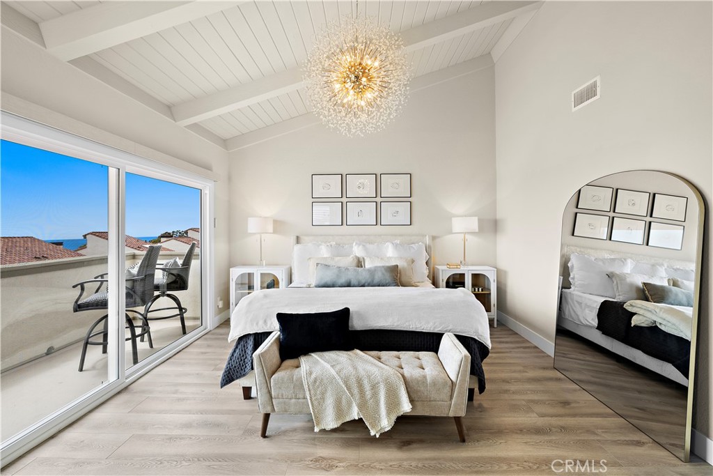 23277 Atlantis Way Dana Point, CA 92629 - Photo 24 of 48 a bedroom with a bed and a chandelier