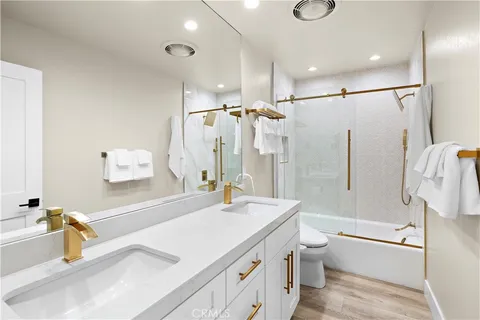 a bathroom with a granite countertop sink a toilet and shower