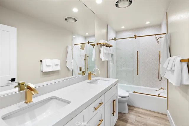 a bathroom with a granite countertop sink a toilet and shower