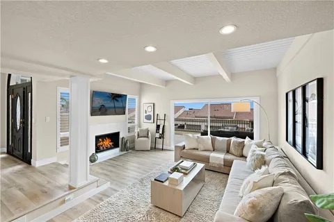 a living room with furniture and a fireplace with wooden floor