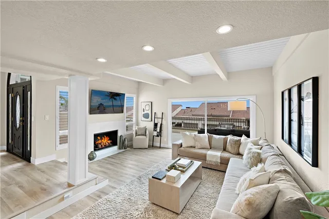 a living room with furniture and a fireplace with wooden floor