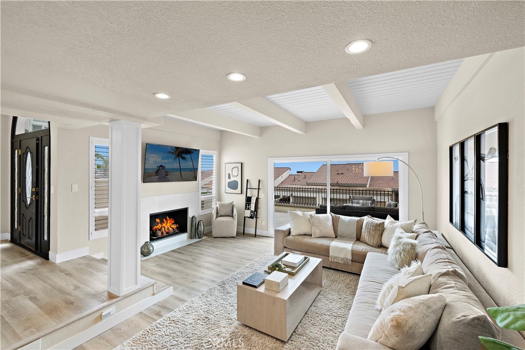 23277 Atlantis Way Dana Point, CA 92629 - Photo 10 of 48 a living room with furniture and a fireplace with wooden floor