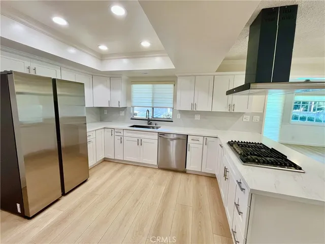 a kitchen with stainless steel appliances granite countertop a stove a sink dishwasher a refrigerator and cabinets with wooden floor