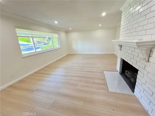 an empty room with wooden floor and fireplace