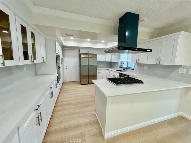 a kitchen with kitchen island granite countertop a sink and a stove top oven