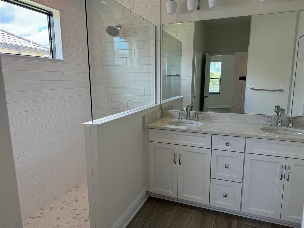 261 Potenza Loop Nokomis, FL 34275 - Photo 13 of 42 a bathroom with a granite countertop sink two mirror and a shower