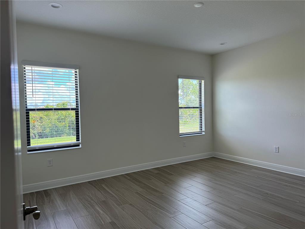 261 Potenza Loop Nokomis, FL 34275 - Photo 16 of 42 a view of an empty room with wooden floor and a window