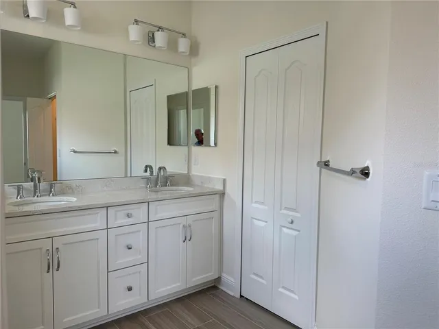a bathroom with double sink and a mirror