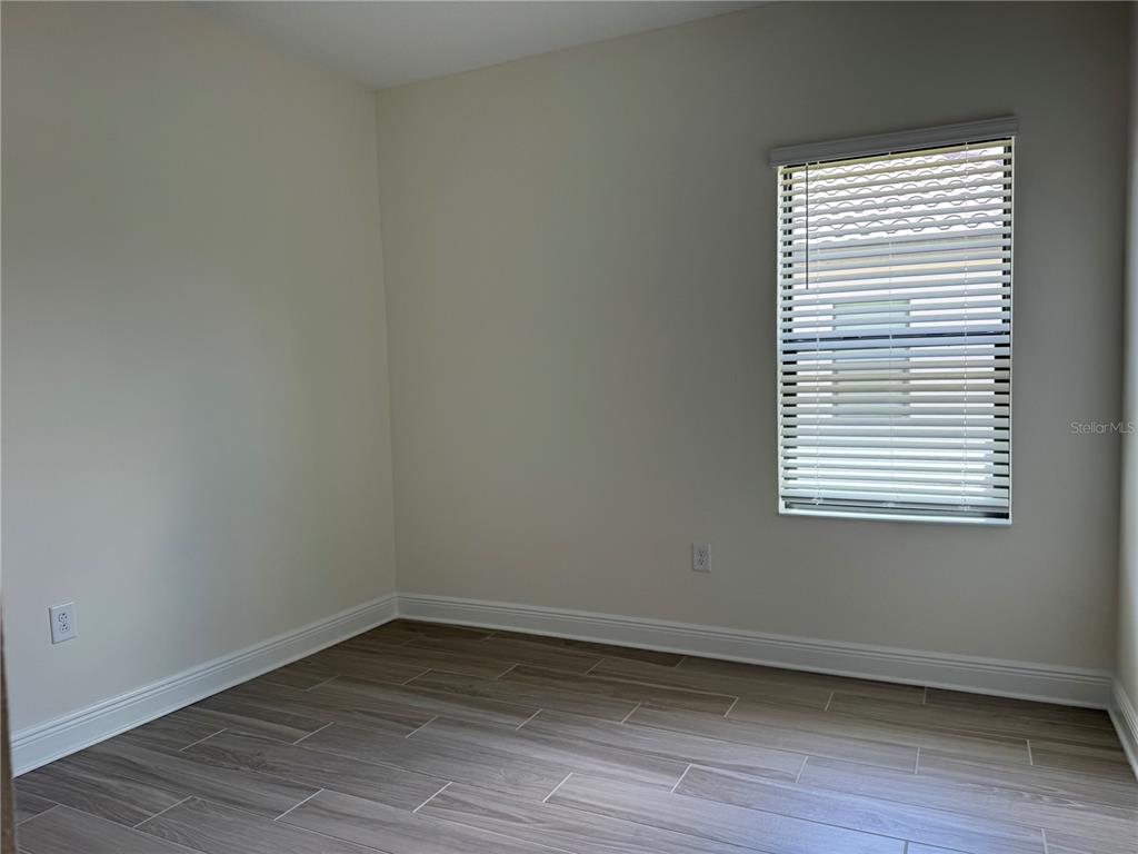 261 Potenza Loop Nokomis, FL 34275 - Photo 20 of 42 a view of an empty room with wooden floor and a window
