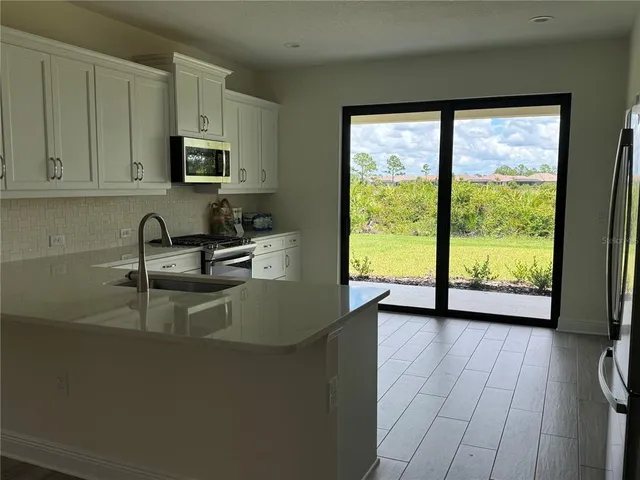 a kitchen with sink a window and cabinets