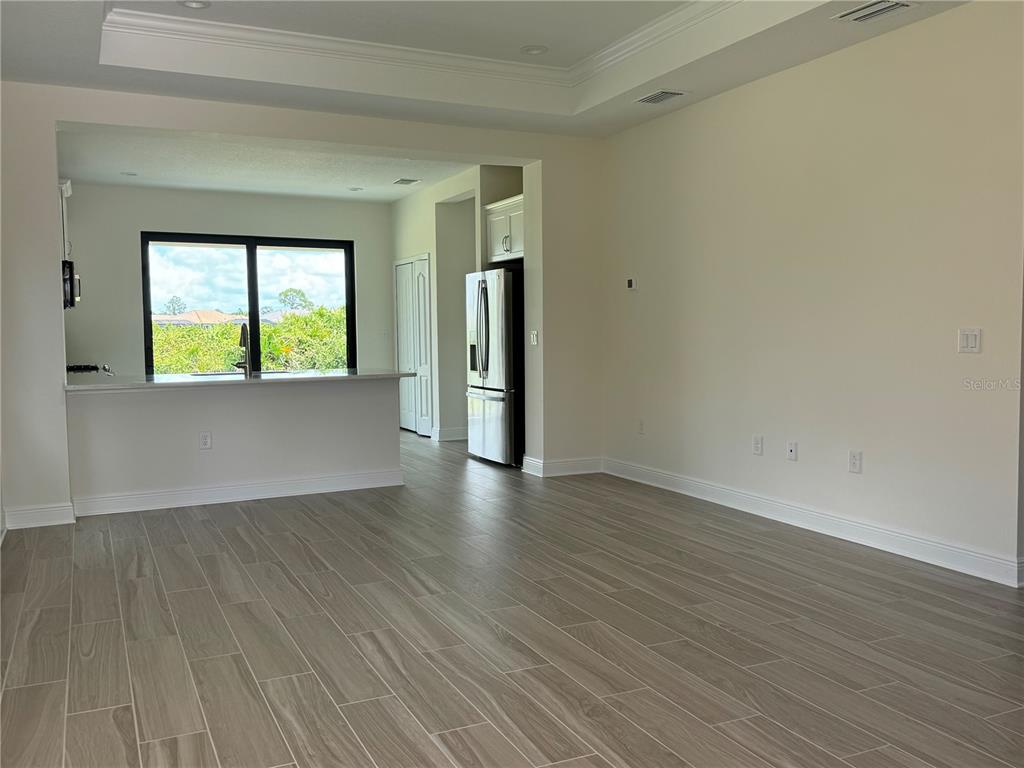 261 Potenza Loop Nokomis, FL 34275 - Photo 3 of 42 an empty room with wooden floor and windows