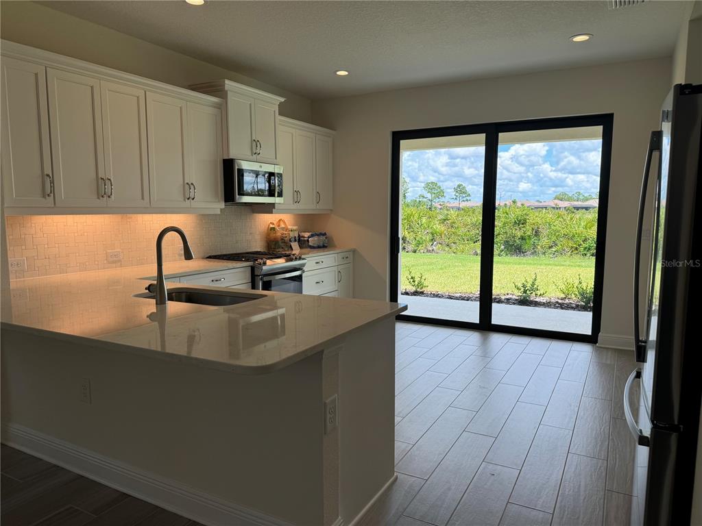 261 Potenza Loop Nokomis, FL 34275 - Photo 5 of 42 a kitchen with sink a large window and cabinets