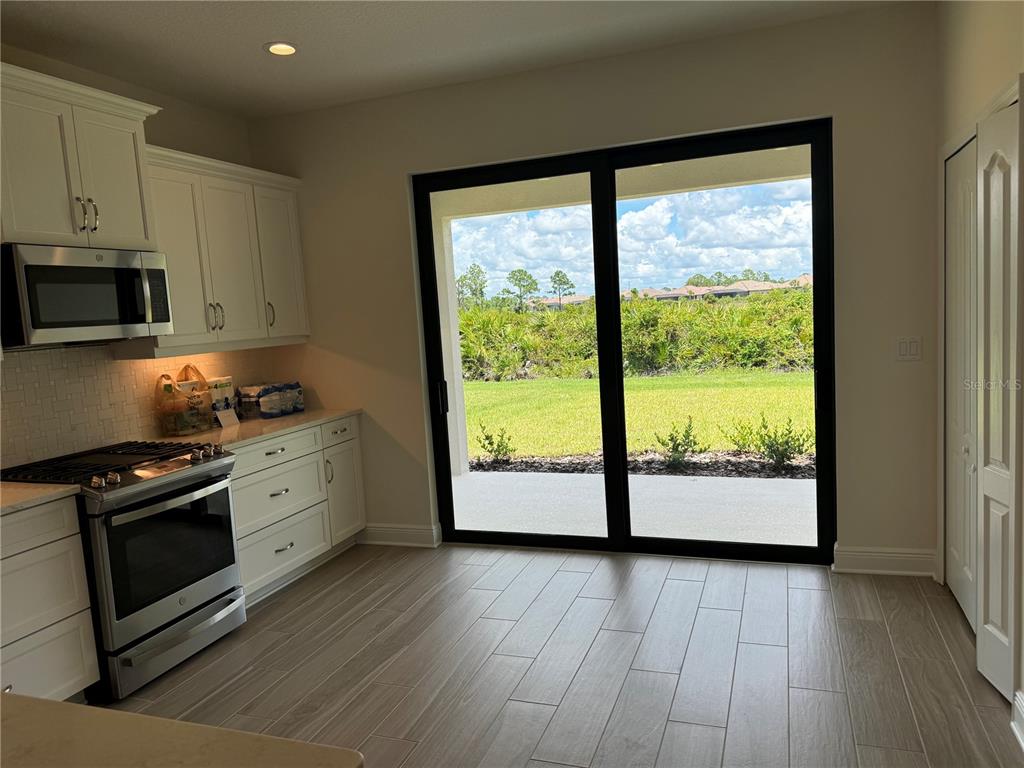 261 Potenza Loop Nokomis, FL 34275 - Photo 7 of 42 a kitchen with wooden floors and white cabinets
