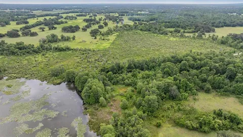 a aerial view of a house with a yard and lake view