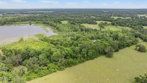 a view of a patio with table and chairs and couches with wooden fence and roof