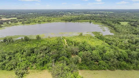 a view of a wooden chairs and fire pit in the backyard