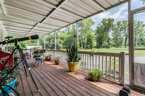 a bedroom with a bed and a large window with wooden floor