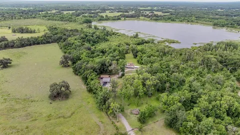 an aerial view of a house with a yard and large trees