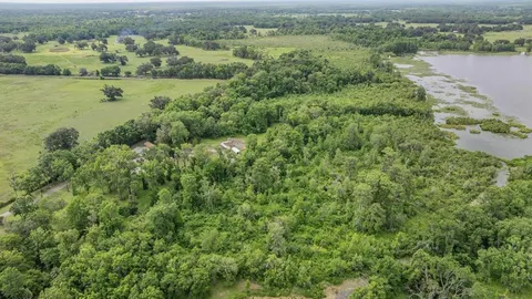 an aerial view of residential houses with outdoor space and river