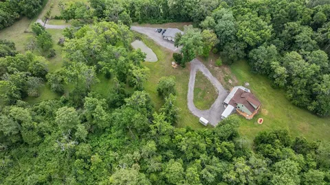 an aerial view of residential houses with outdoor space and lake view