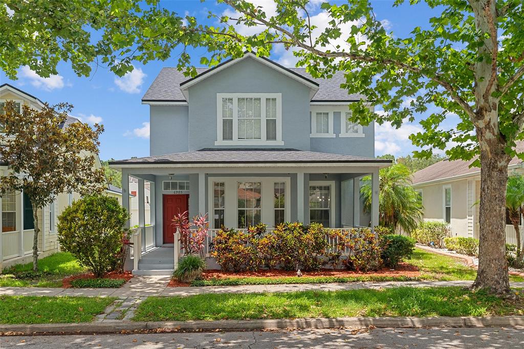 a front view of a house with a yard and potted plants