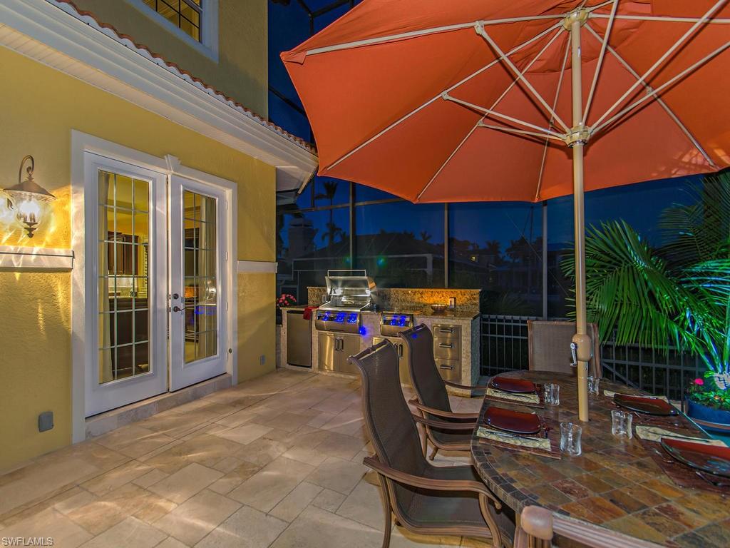 1835 Kingfish Road Naples, FL 34102 - Photo 17 of 23 a view of a patio with table and chairs under an umbrella