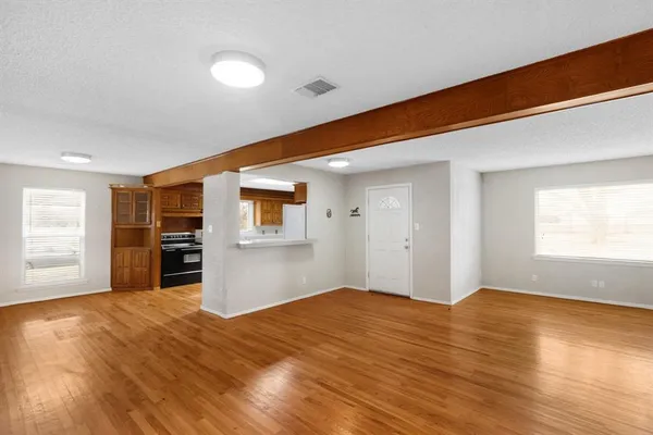 a big room with wooden floor and windows