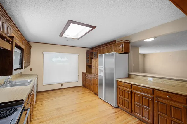 a kitchen with stainless steel appliances granite countertop a refrigerator and a sink