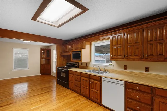 a kitchen with stainless steel appliances wooden cabinets a sink and a stove