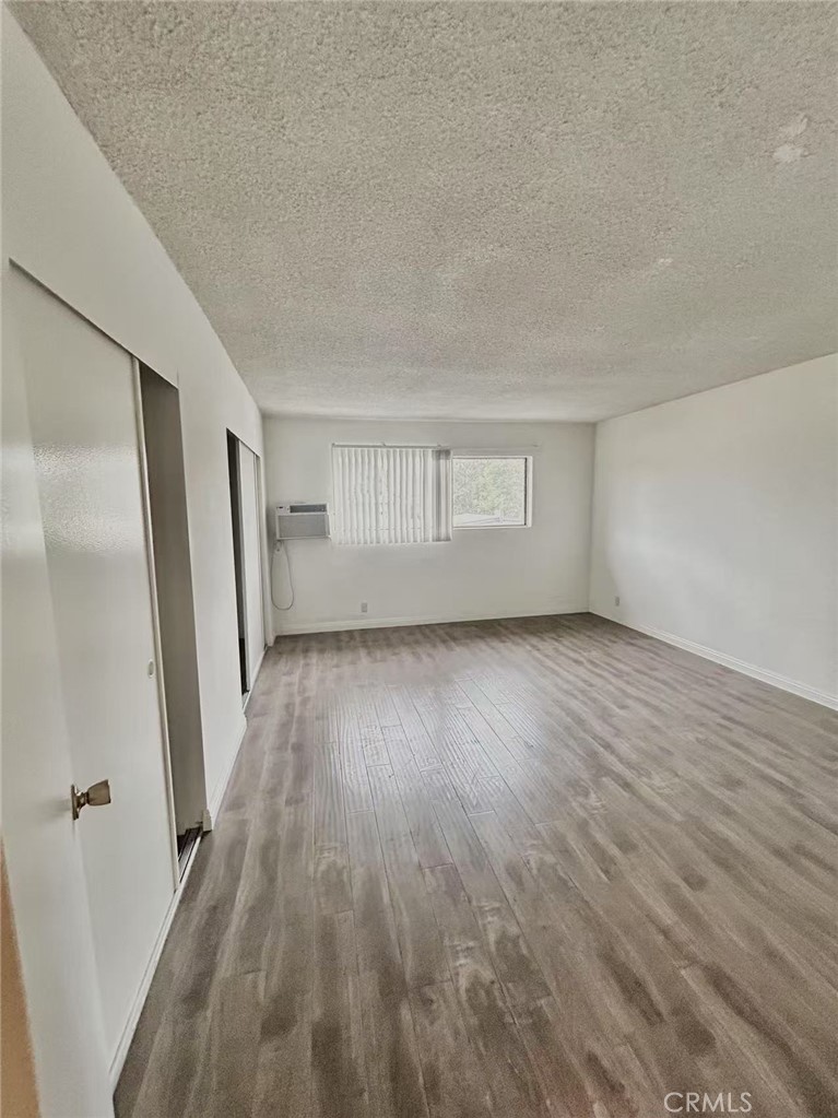 922 West Duarte Road, Unit 3 Arcadia, CA 91007 - Photo 14 of 16 an empty room with wooden floor and windows