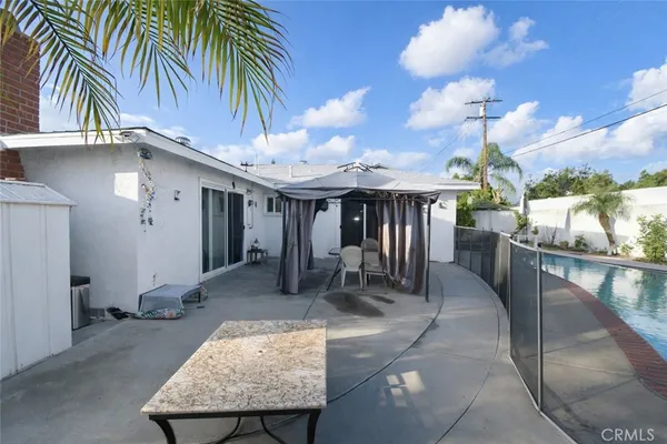 a view of a house with backyard and sitting area