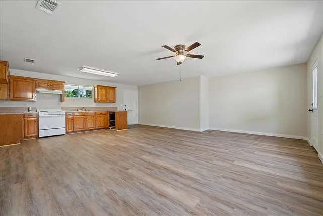 a view of a room with wooden floor and ceiling fan