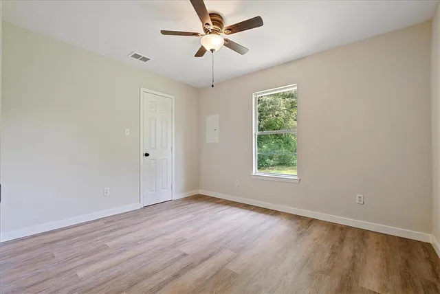 wooden floor in an empty room with a window