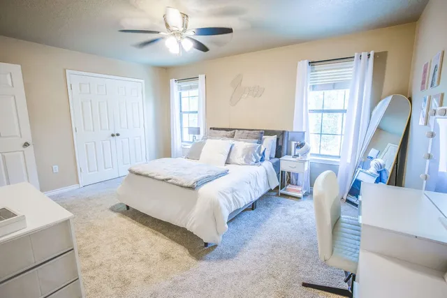 a spacious bedroom with a bed and a chandelier