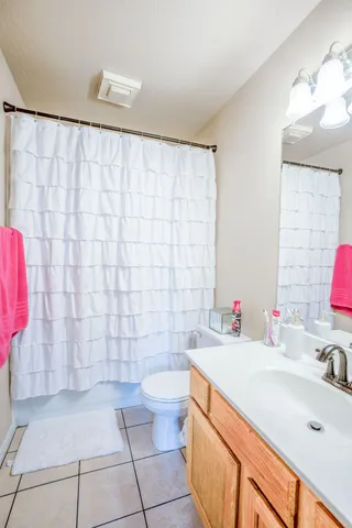 a bathroom with a sink a toilet and shower curtain